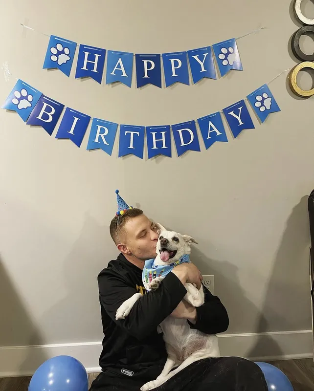 Birthday party photo: Zech and Betsy under a paw-print birthday banner